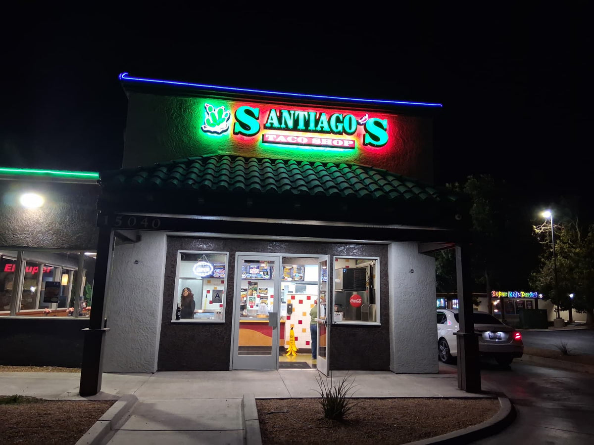 Illuminated restaurant storefront sign with dimensional letters at night.