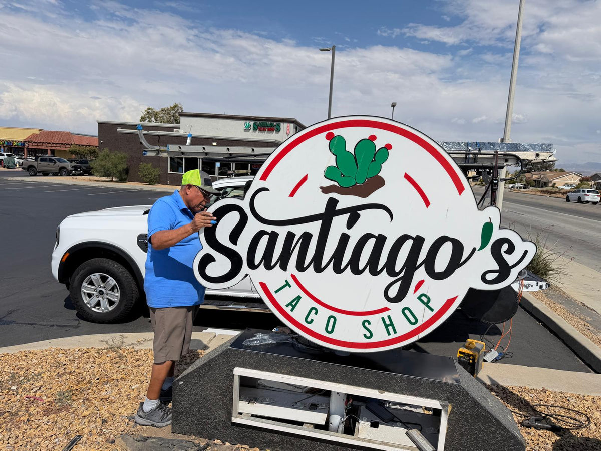 Large circular custom monument sign being installed beside a parking lot.