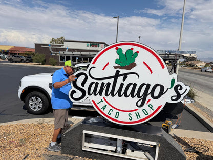 Large circular custom monument sign being installed beside a parking lot.