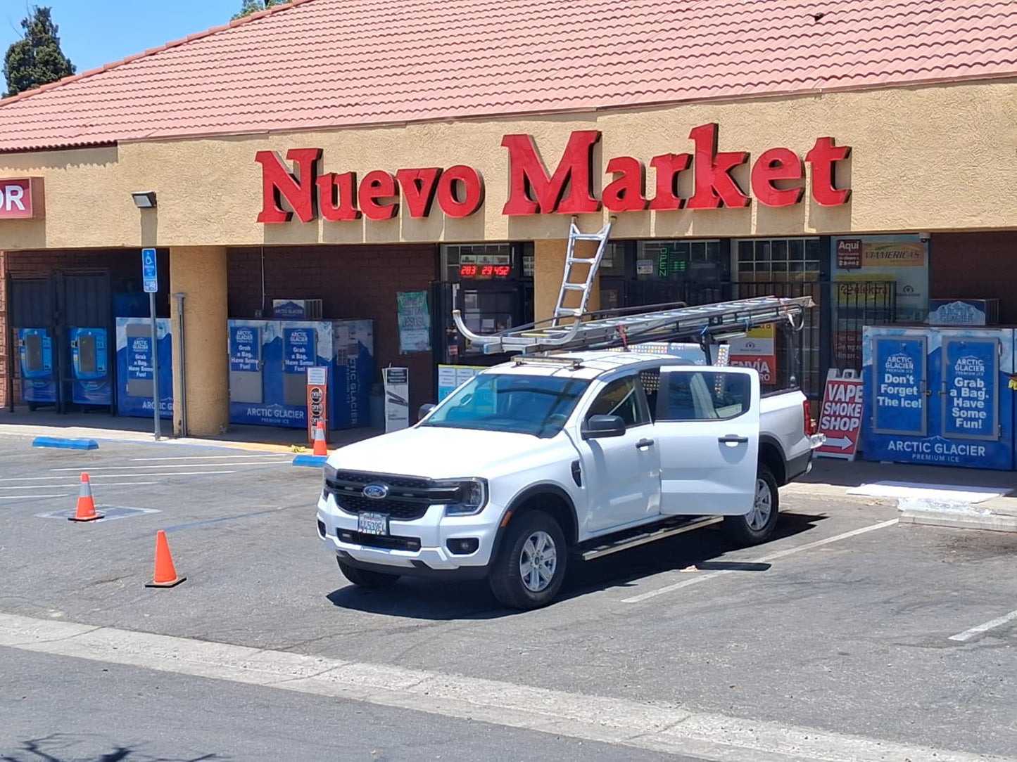 Large red dimensional storefront letters installed above a market entrance.