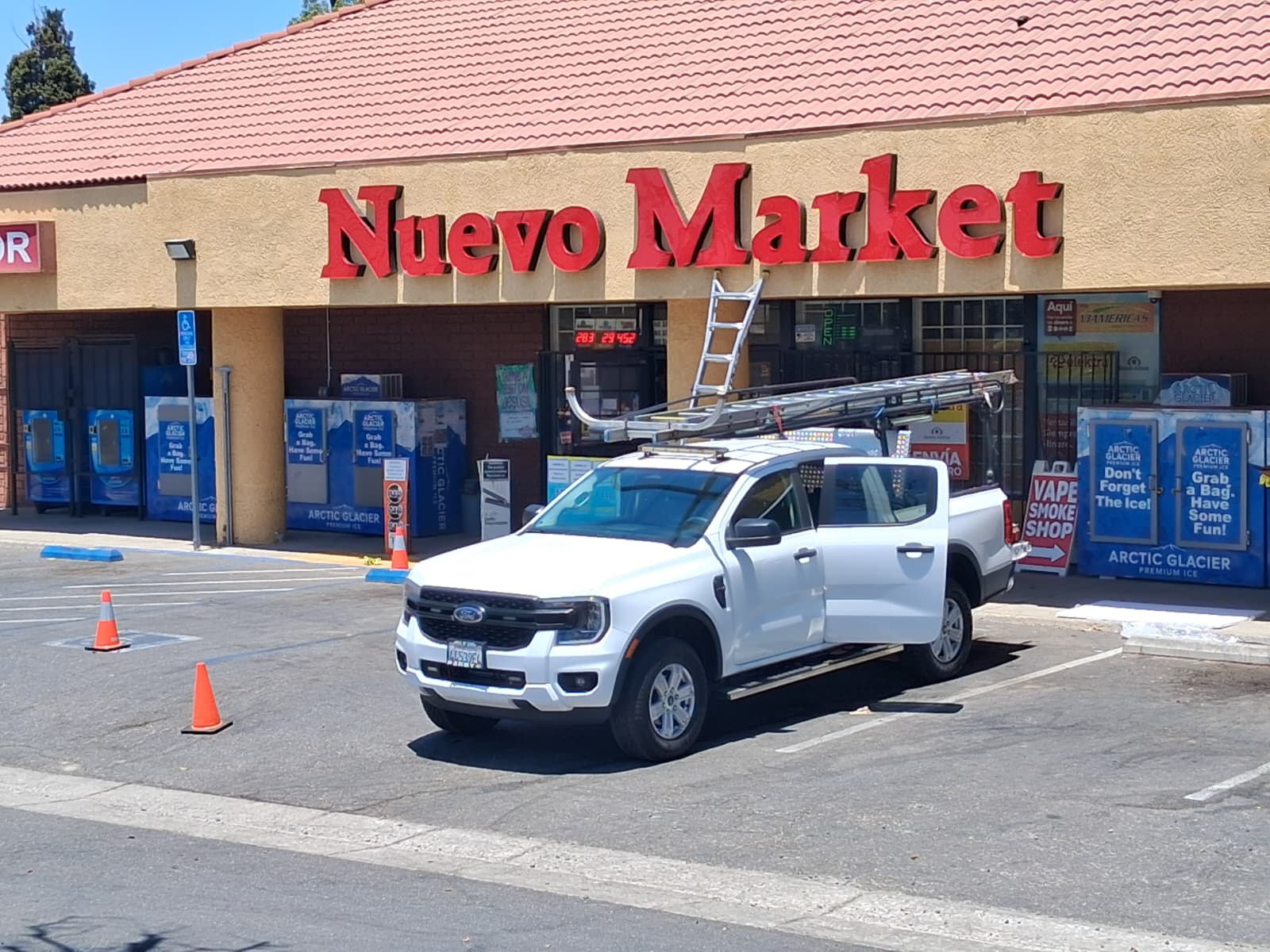 Large red dimensional storefront letters installed above a market entrance.