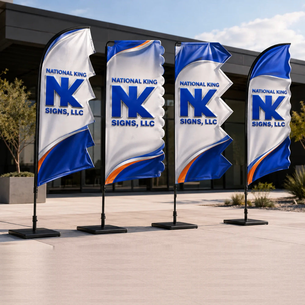 Four National King Signs branded festival and event flags with distinctive shaped edges, blue and white graphics with orange accents, and black bases outside a modern building.