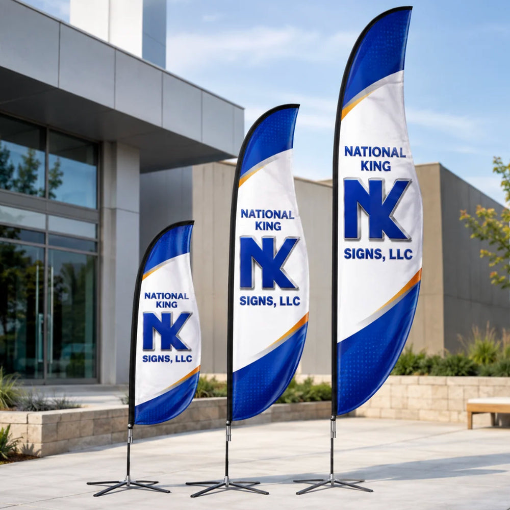 Three National King Signs branded blade flags in different heights, with blue, white and gold graphics and black cross bases outside a modern building.