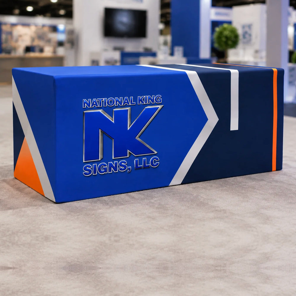 National King Signs branded fitted table cover in royal blue and navy with white and orange accents, displayed at a trade show.